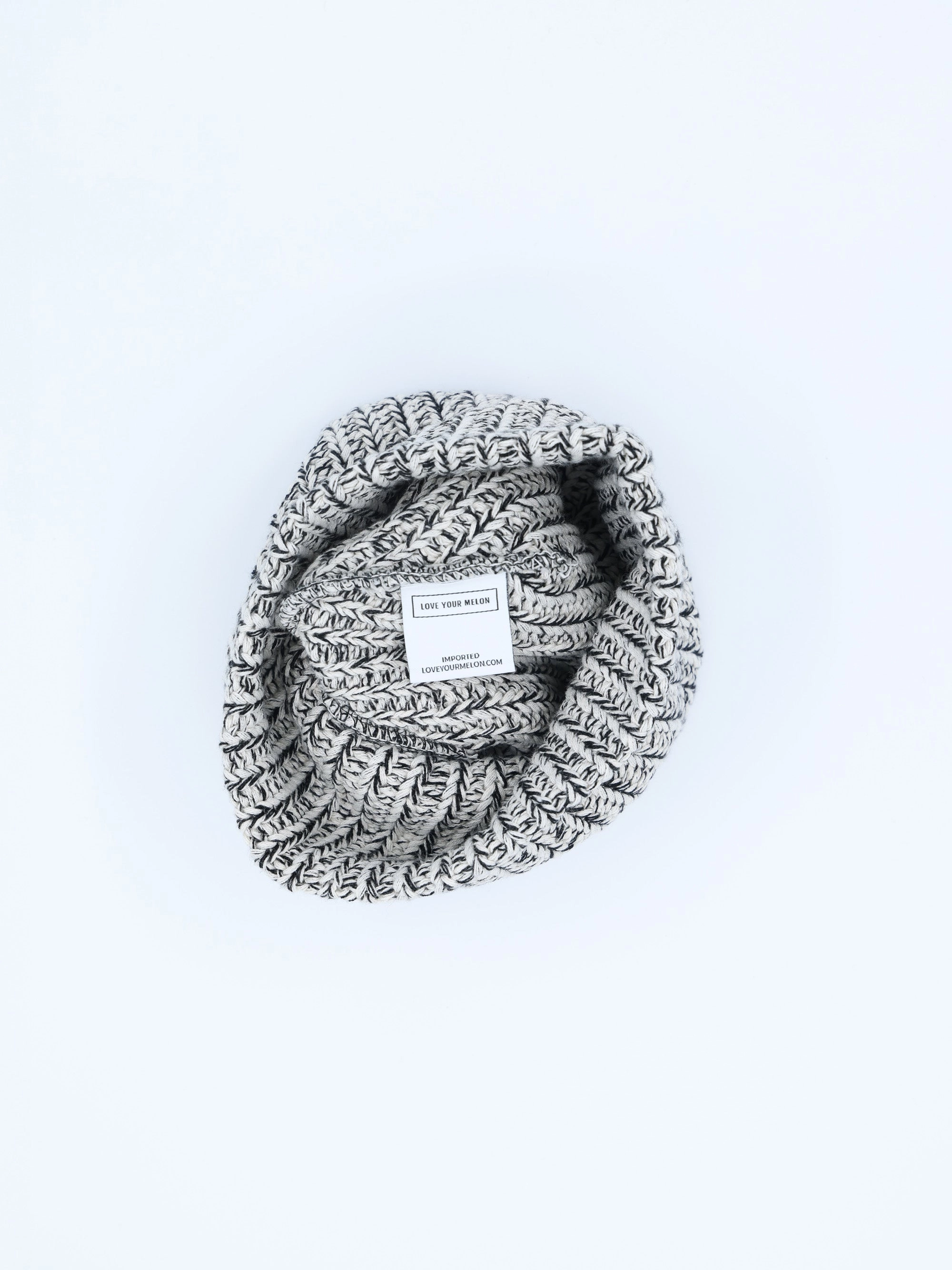 A speckled Essentials beanie rolled up, inside label showing