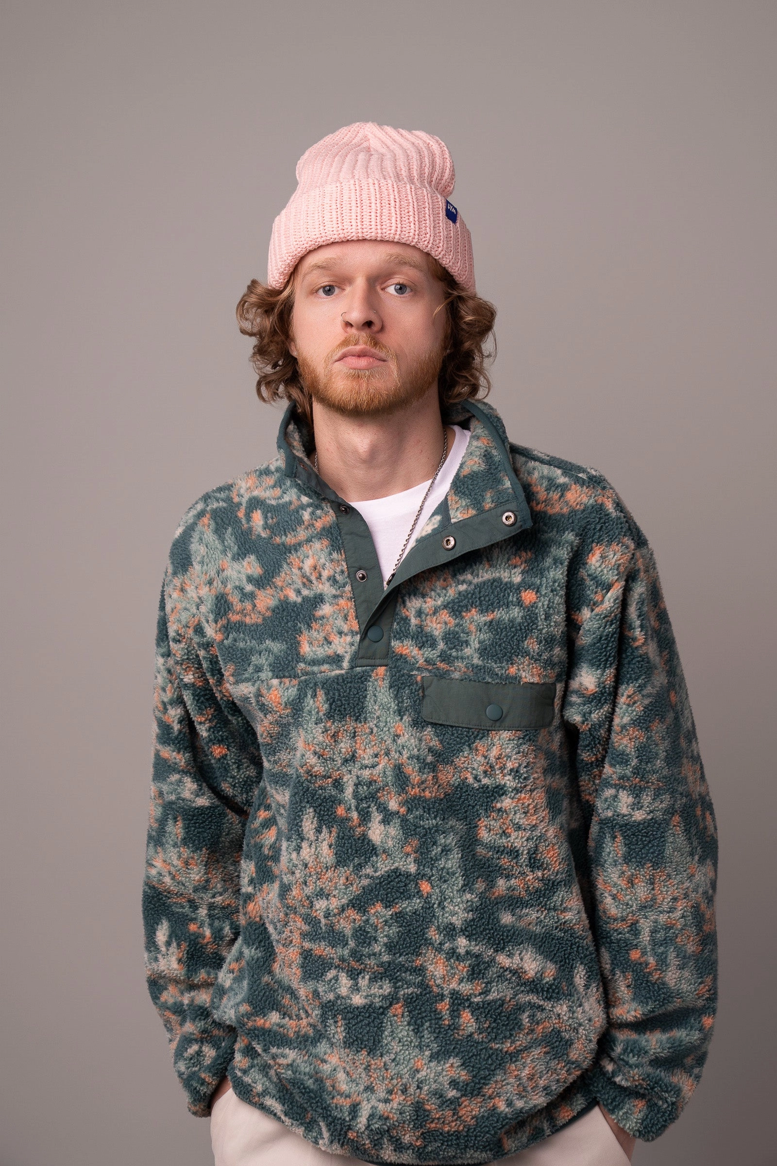 A man in a blush LYM beanie and a camo fleece